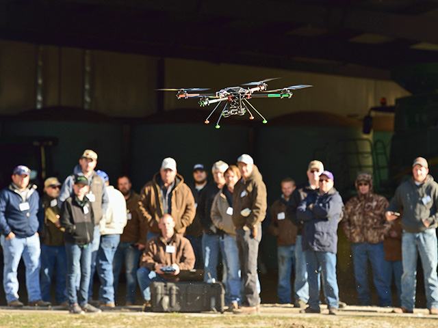 At a UAV workshop in Kansas, farmers and others watch a drone go through its paces. (Progressive Farmer photo by Jim Patrico)